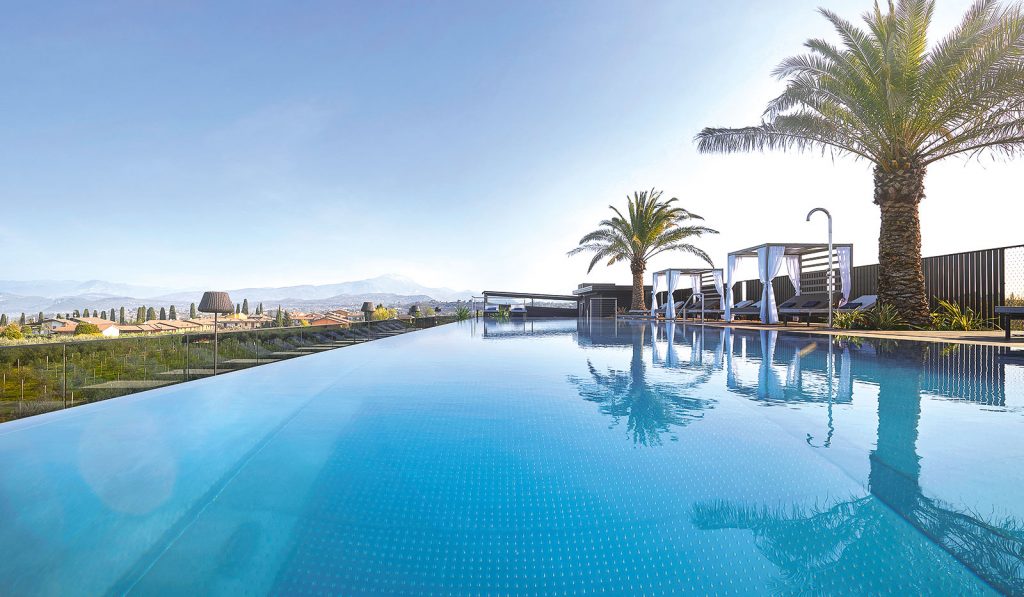 Außenpool umgeben von Palmen des Quellenhof Luxury Resorts Gardasee