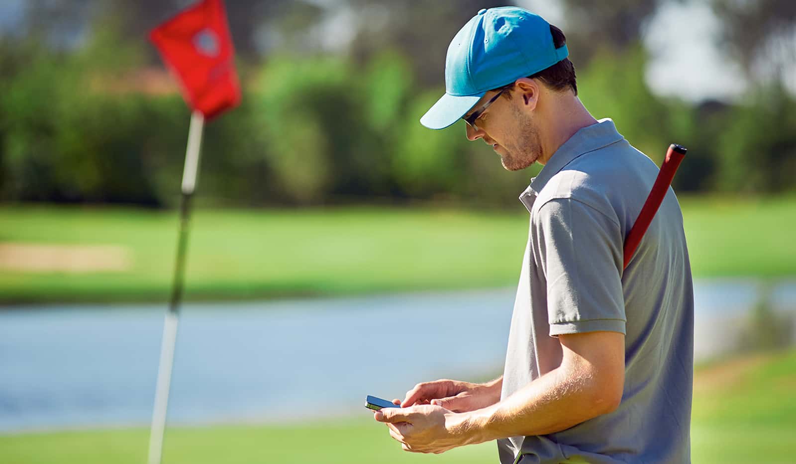 Golfer mit Smartphone auf dem Golfplatz