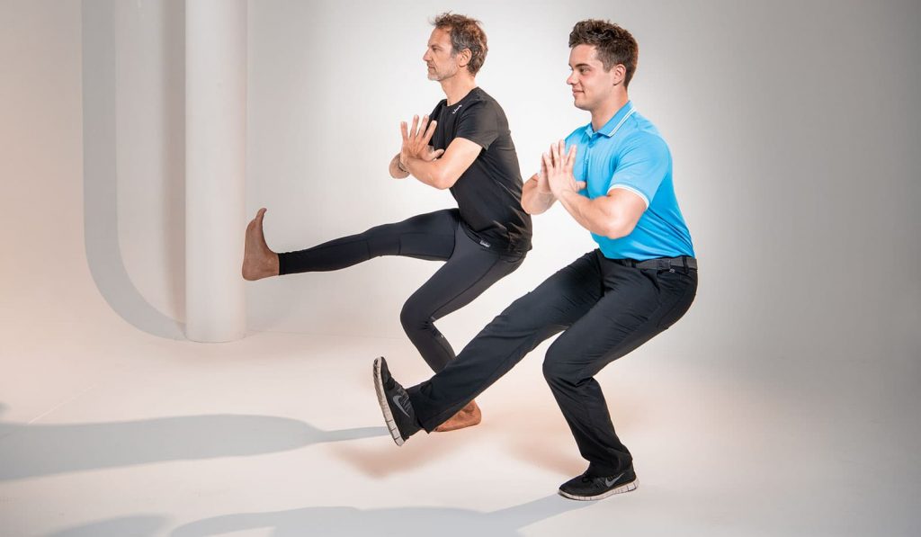Pilatesübung "einbein Kniebeuge" mit Sven Dyhr und Christian Lutz