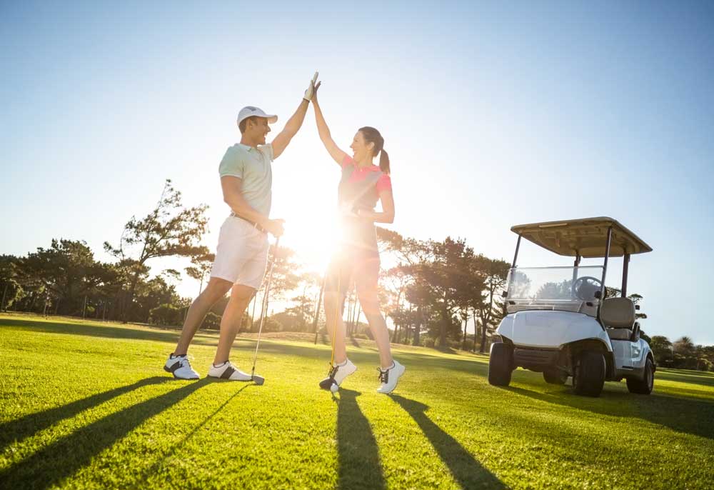 Golferin und Golfer mit Club Car
