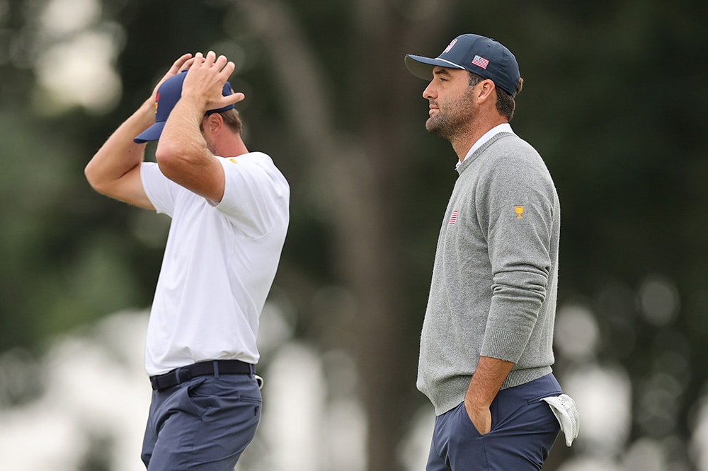 Sam Burns hält die Hände an den Kopf, neben ihm steht Scottie Scheffler beim Presidents Cup 2026 in Medinah.
